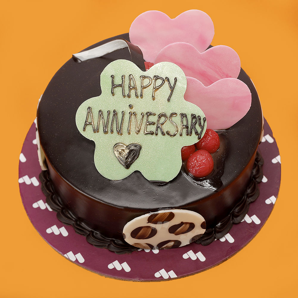 A cake with two hearts adjoined in red and white theme with golden dots. A  cake perfect for anniversary – Creme Castle